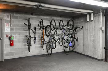 A bike rack with several bicycles hanging on it.